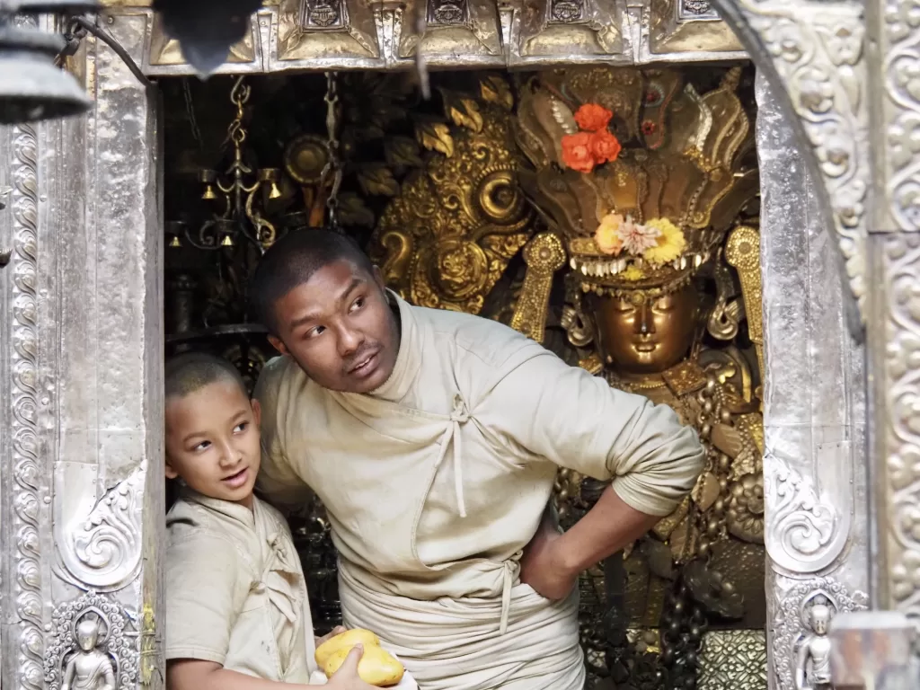Culture travel in Nepal capturing Buddhist priests gathered at the historic Golden Temple in Patan.