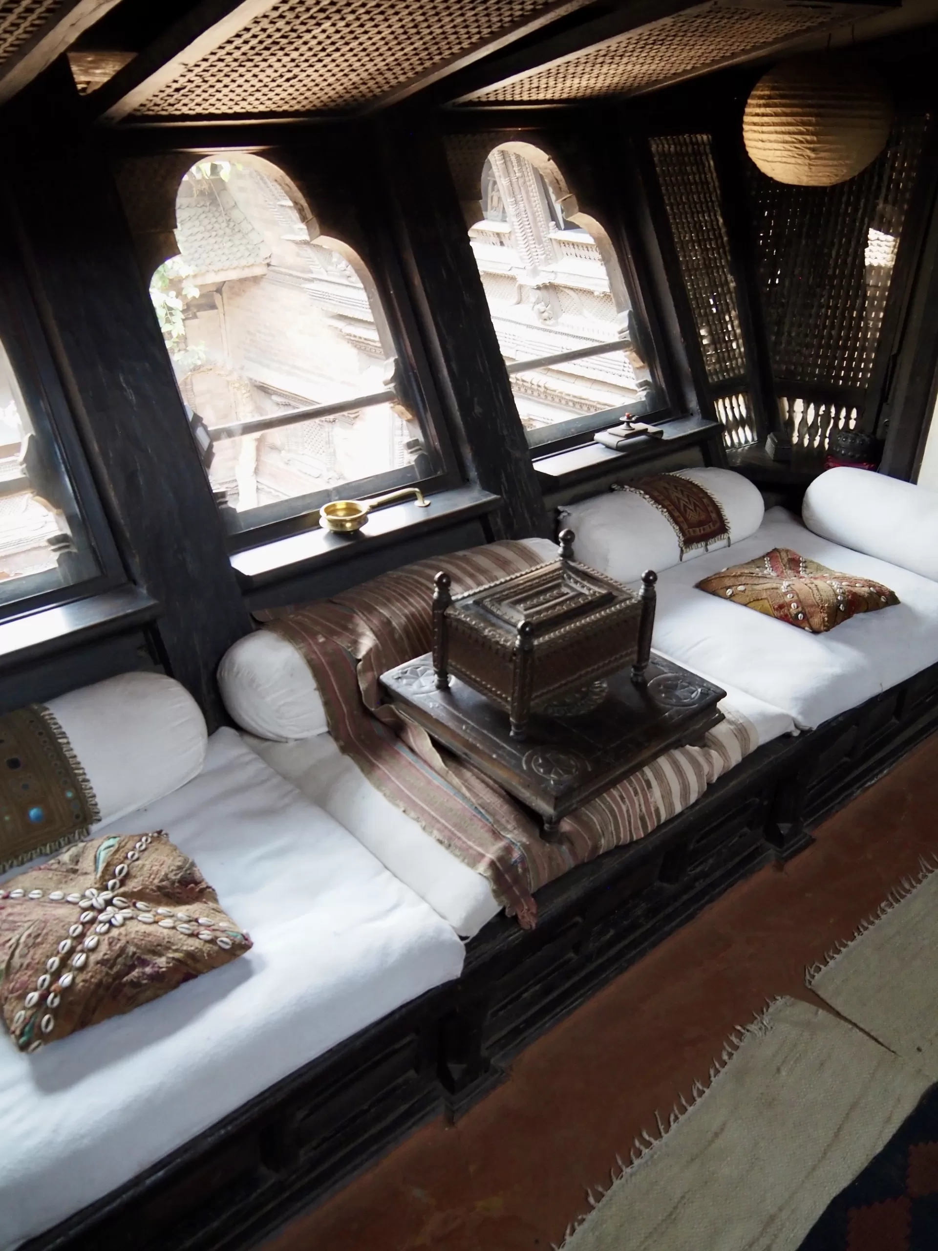 Window seat with ethnic textiles in baithak of Kutu Math, the Bhaktapur home of the conservation architect Götz Hagmüller.