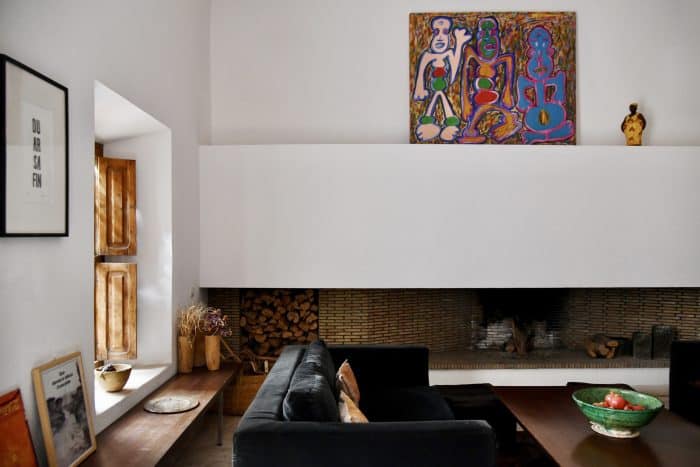 Architectural fireplace, modern sofas and painting by Indonesian artist Ribka Chanson-Hendriks in the salon of Riad UP, Marrakech.