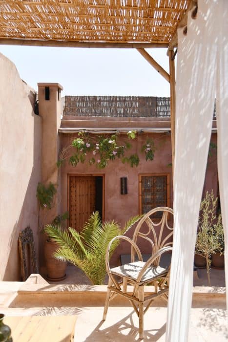 Cane chair under the thatched canopy of the roof terrace, Riad UP, Marrakech.