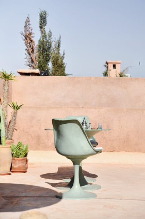 Eero Saarinen tulip chairs and table painted sage green, roof terrace, Riad UP, Marrakech.
