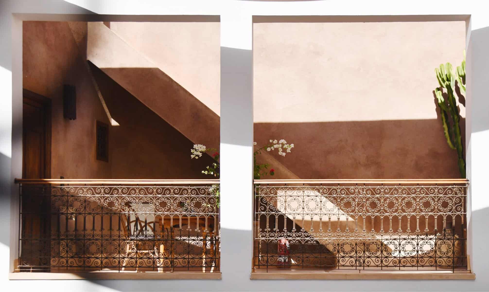 Riad UP. Terrace with small cane table and chairs and rammed-earth staircase, Riad UP, Marrkaech.