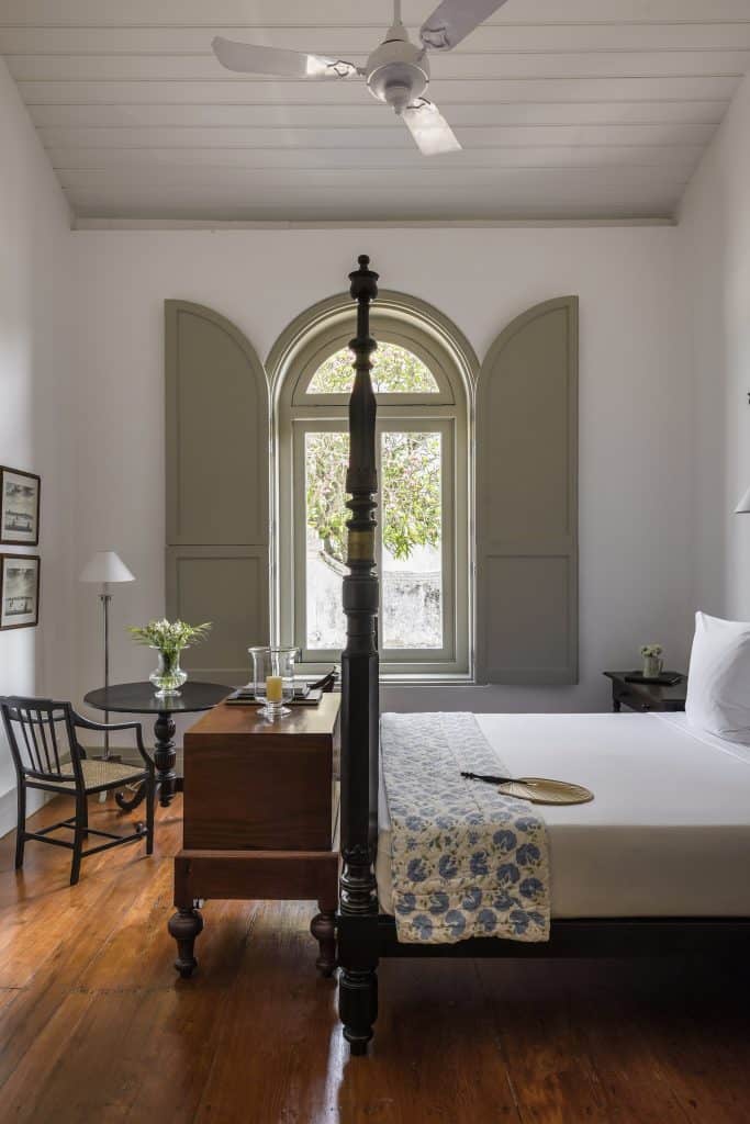 Amangalla. Guest room with fourposter bed, colonial chest and shutters at Amangalla, Galle Fort, Sri Lanka.
