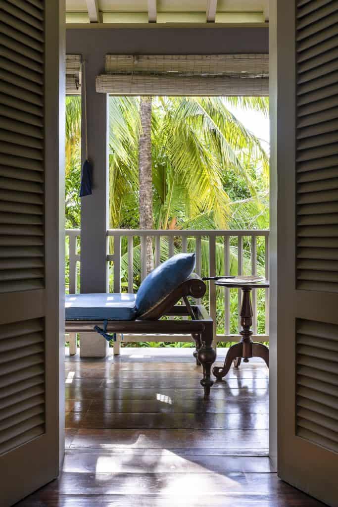 Amangalla. Anglo-Indian daybed with views of dense palm trees on the veranda of Amangalla hotel, Galle Fort.