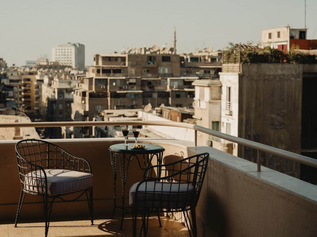 Aperitivo on the terrace at The Immobilia, with 1950s style metal patio furniture and views of Downtown Cairo.