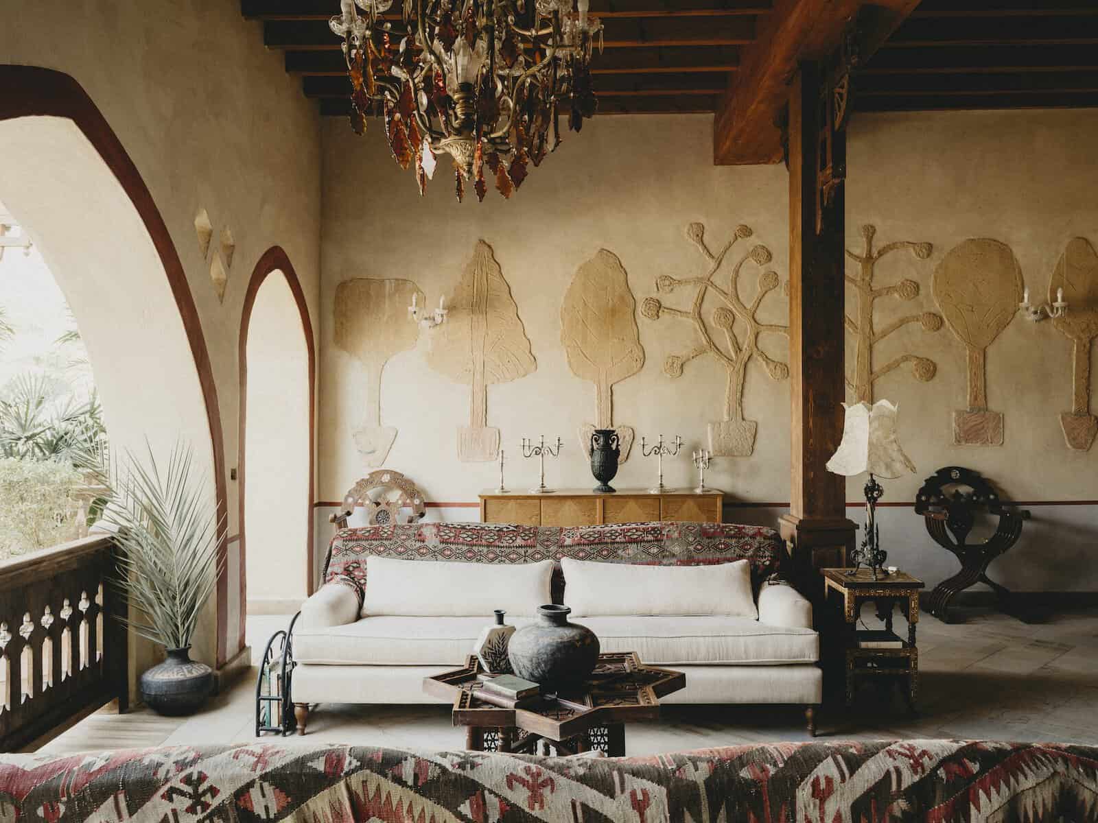 Sofa and chandelier in front of striking wall sculpture at Villa Fayoum, part of the portfolio of Egypt Beyond.