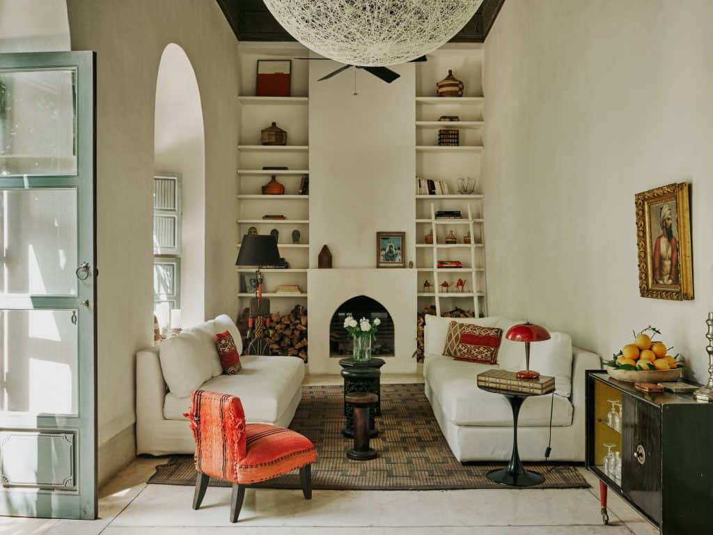 Eclectic salon anchored by a Tuareg mat fireplace & vintage pieces at Riad Mena Marrakech.