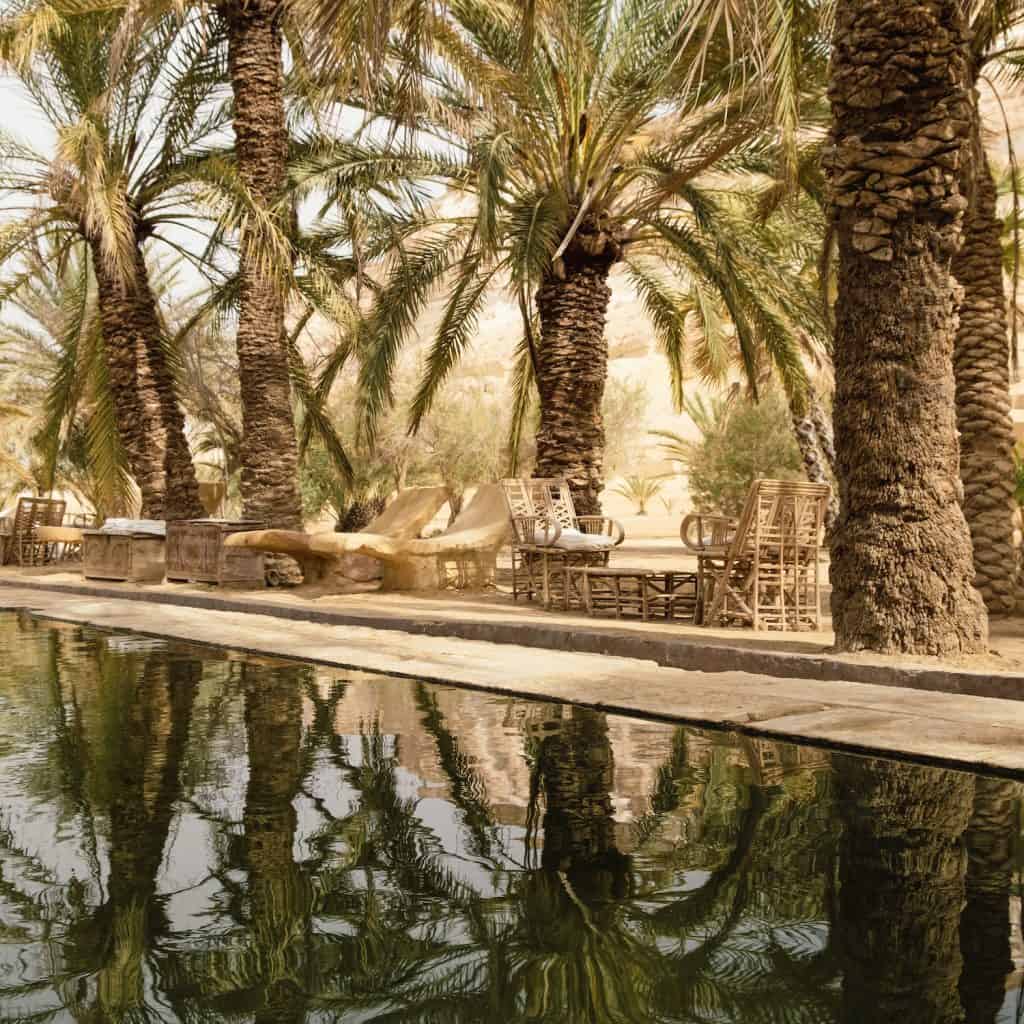 Rustic outdoor furniture by the pool at Adrere Amellal in Siwa Oasis, Egypt.