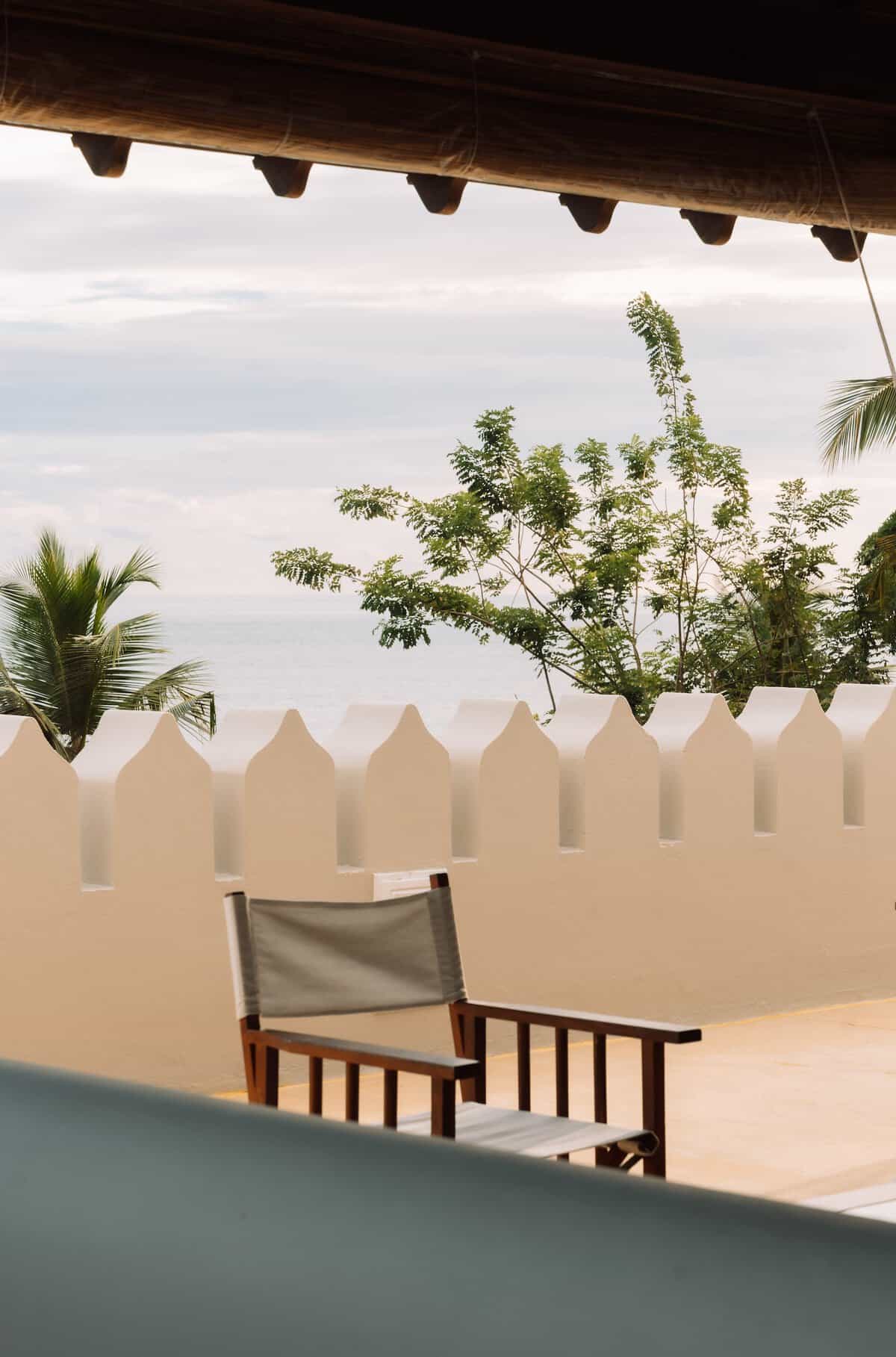 On Houses Welligama. A deck chair in front of Swahili merlens, or stepped battlements, on the roof terrace of On Houses Welligama.